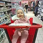 Sourire, Photograph, Meubles, Shelf, Customer, Red, Chair, Shopping, Retail, Shopping Cart, Shelving, Service, Publication, Outdoor Furniture, Convenience Store, Wheel, Happy, Enfant, Trade, Personne, Joy, Headwear