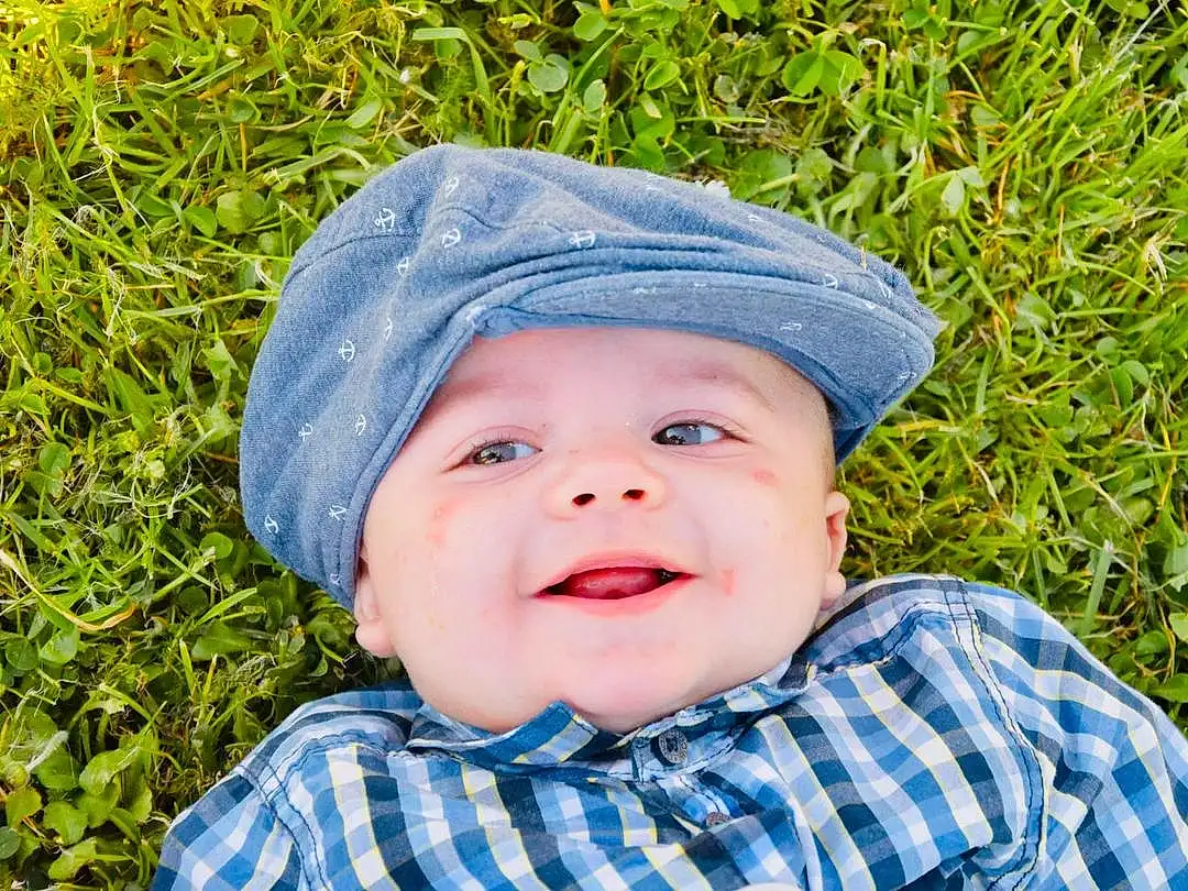 Visage, Head, Sourire, Chin, Yeux, Chapi Chapo, People In Nature, Leaf, Baby, Happy, Sleeve, Headgear, Cap, Herbe, Bambin, Baby & Toddler Clothing, Plante, Plaid, Tartan, Sun Hat, Personne, Headwear
