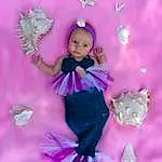 Purple, Jouets, Doll, Rose, Violet, Petal, Dress, One-piece Garment, Magenta, Fashion Design, Happy, Embellishment, Baby & Toddler Clothing, Ruffle, Day Dress, Formal Wear, Angel, Pattern, Event, Fictional Character, Personne, Headwear