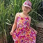 Clothing, Sourire, Lunettes, Plante, Shoulder, One-piece Garment, Jambe, Dress, Day Dress, Waist, Rose, People In Nature, Sunglasses, Thigh, Faon, Baby & Toddler Clothing, Herbe, Summer, Magenta, Fashion Design, Personne, Joy, Headwear