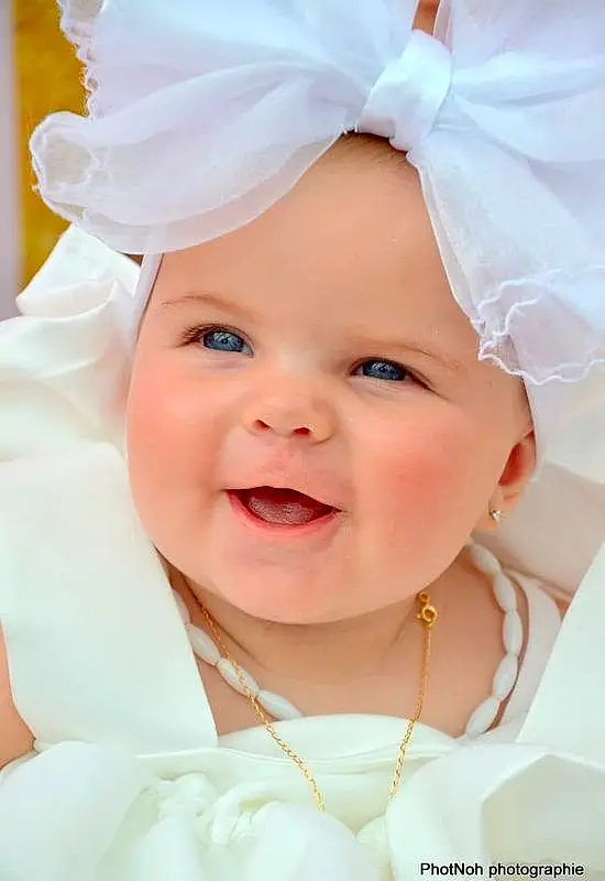 Visage, Sourire, Peau, Photograph, Facial Expression, Blanc, Dress, Happy, Baby & Toddler Clothing, Gesture, Rose, Baby, Bambin, Headgear, Fun, Headpiece, Beauty, Baby Laughing, Event, Personne, Joy, Headwear
