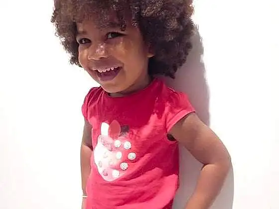 Hair, Head, Lip, Sourire, Coiffure, Jheri Curl, Afro, Sleeve, Gesture, Happy, Waist, Rose, Cool, Thigh, Baby & Toddler Clothing, Wig, Magenta, T-shirt, Fashion Design, Personne, Joy