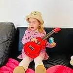 Jambe, Comfort, Chapi Chapo, Musical Instrument, String Instrument, Thigh, Rose, Baby & Toddler Clothing, Couch, Lap, Plucked String Instruments, Knee, String Instrument Accessory, Bambin, Human Leg, Assis, Sock, Fun, Magenta, Personne, Headwear