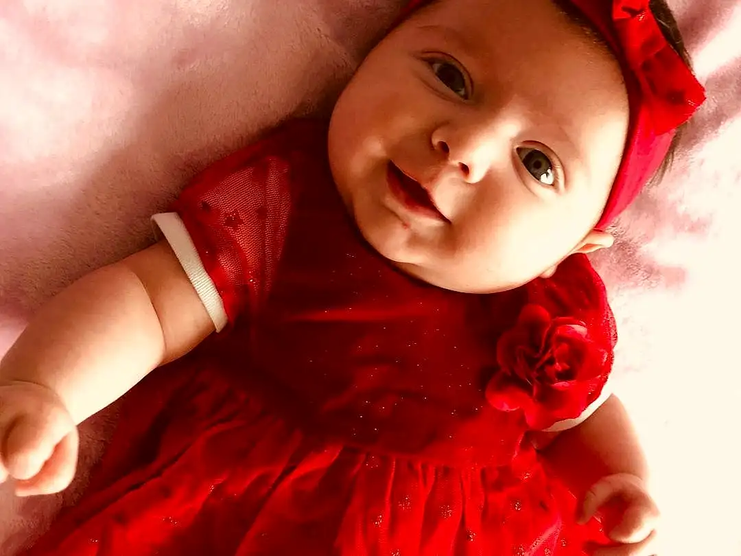 Peau, Head, Lip, VÃªtements dâ€™extÃ©rieur, Sourire, Yeux, Dress, Baby & Toddler Clothing, Textile, Flash Photography, Sleeve, Happy, Gesture, Iris, Rose, Bambin, Red, Magenta, Day Dress, Embellishment, Personne, Headwear
